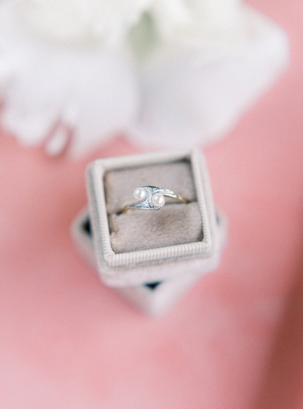 The top view of a Double Pearl and Diamond Vintage Engagement Ring in 9k Yellow White Gold sitting in a beige ring box stack. Antique Engagement Rings Canada. Canadian vintage engagement rings. Vintage engagement rings Canada. Bridal jewelry Canada. Canadian weddings. Wedding Canada. Canadian jewelry brands. Affordable Canadian jewelry brands. Canadian bridal jewelry. Woman-owned Canadian jewelry brand. Pearl jewelry Canada. Pearl Bridal jewelry Canada. Organic pearl jewelry.