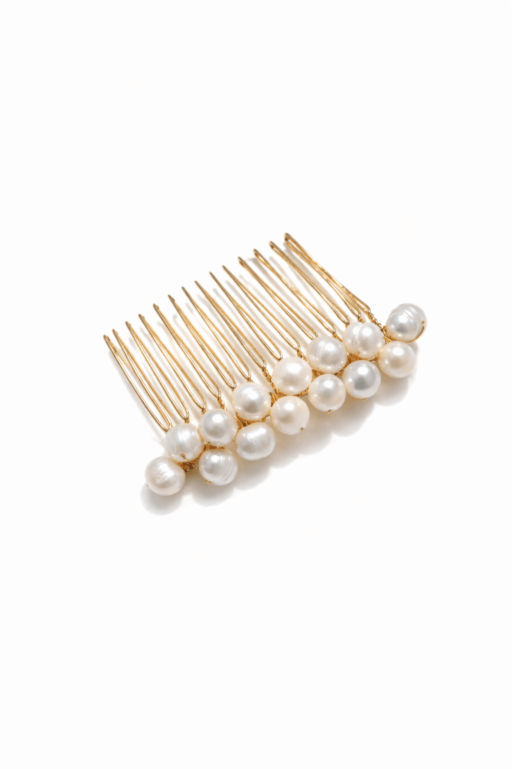 Gold hair comb with freshwater pearls on a white background. Pearl bridal hair accessories for weddings; handmade by a Canadian jewelry designer.