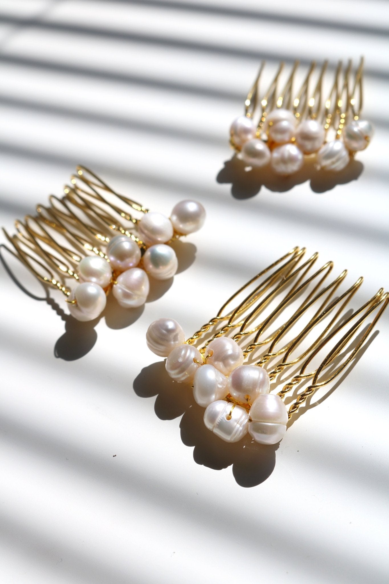 Three smaller bridal hair combs with bigger clustered freshwater pearls in gold. Affordable Canadian jewelry brands. Handmade Canadian jewelry. Canadian jewelry business. Organic pearl jewelry. Pearl jewelry sets. Bridal jewelry Canada. Pearl jewelry Canada. Pearl Bridal jewelry Canada. Canadian jewelry designer. Canadian jewelry designs. Pearl Hair Accessories.