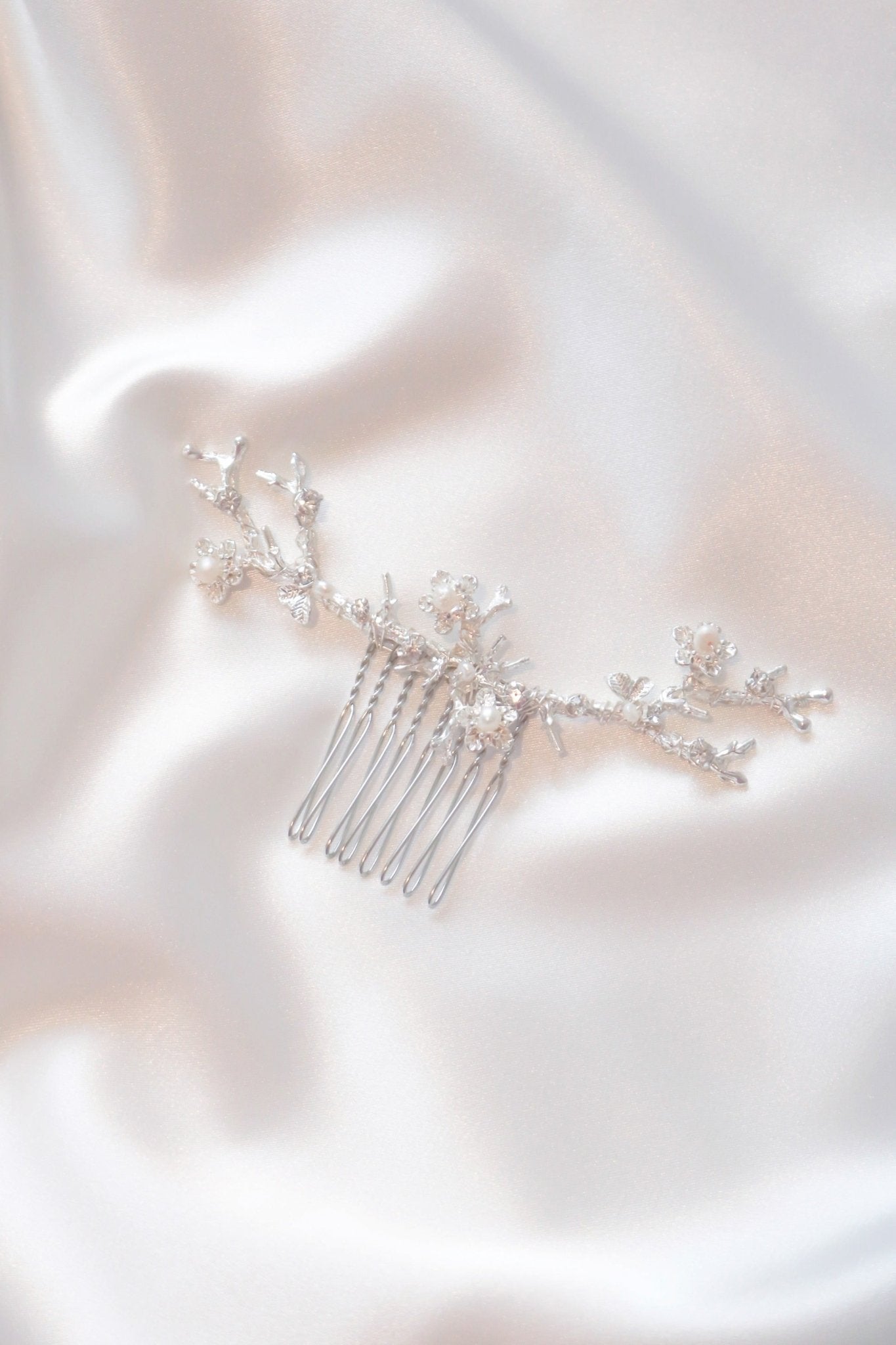 Anthea wide bridal hair accessory silver floral hair comb with fresh water pearls on white satin. Organic pearl accessories. Pearl Bridal Hair Accessories. Pearl Bridal Accessories. Bridal Hair Accessories. Bridal Accessories. Canadian Bridal Accessories. Handmade Canadian Accessories. Canadian handmade Accessories. Canadian weddings. Wedding Canada.
