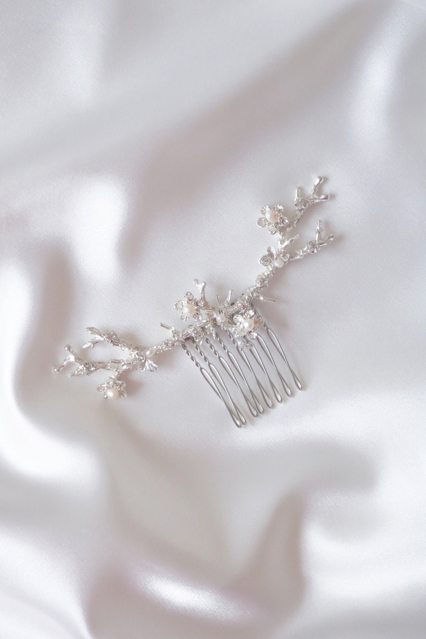 Anthea wide bridal hair accessory silver floral hair comb with fresh water pearls on white satin. Organic pearl accessories. Pearl Bridal Hair Accessories. Pearl Bridal Accessories. Bridal Hair Accessories. Bridal Accessories. Canadian Bridal Accessories. Handmade Canadian Accessories. Canadian handmade Accessories. Canadian weddings. Wedding Canada.