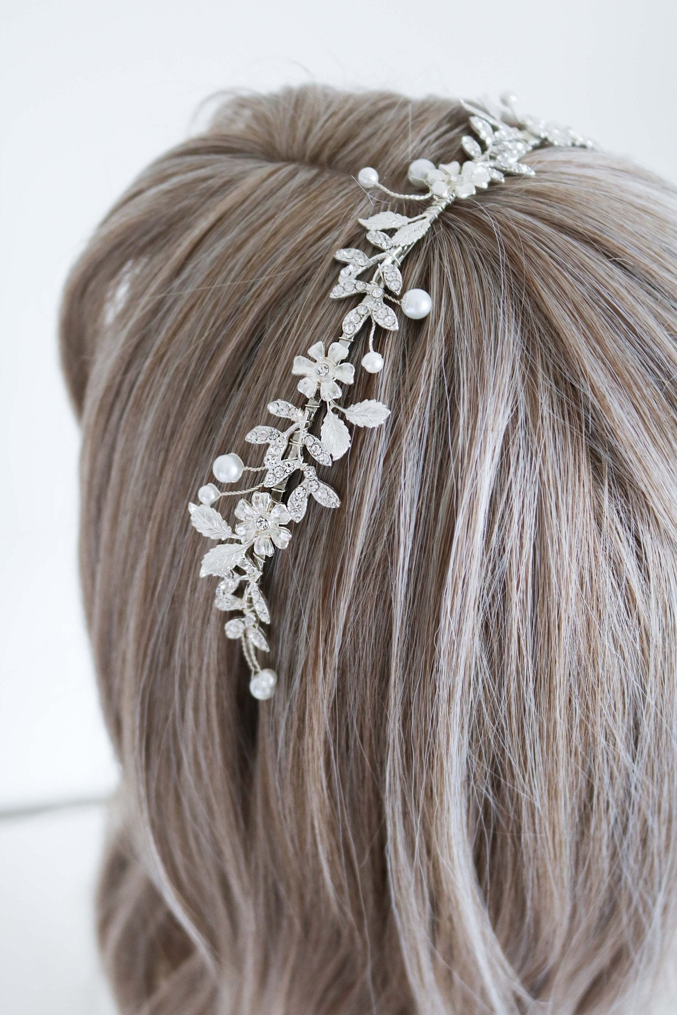 Astoria crystal and pearl bridal headband in silver sits in the hair of a display head bust. Bridal Hair Accessories. Bridal Accessories. Canadian Bridal Accessories. Handmade Canadian Accessories. Canadian handmade Accessories. Canadian weddings. Wedding Canada. Canadian designer. Canadian artist. Pearl Bridal accessories Canada. Organic pearl accessories.