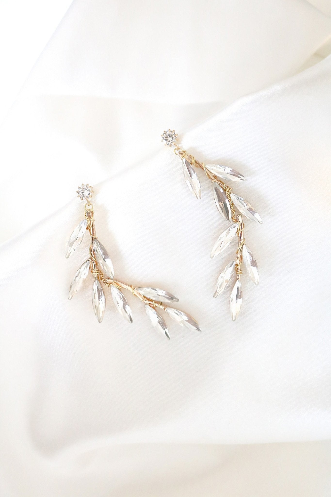 Gold wire-wrapped crystal leaf studs on white backdrop. Gold-filled jewelry Canada. Gold-filled Canadian jewelry. Canadian jewelry brands. Affordable Canadian jewelry brands. Handmade Canadian jewelry. Canadian handmade jewelry. Canadian bridal jewelry. Statement Earrings. Statement Bridal Earrings. Canadian jewelry business.