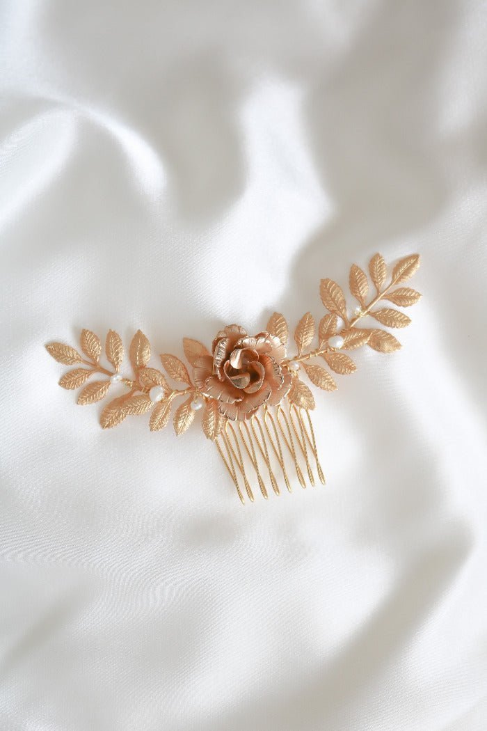 Gold bridal hair comb with floral design on a white fabric background. Bridal hair accessories & Canadian bridal accessories handmade by a Woman-owned Canadian jewelry brand