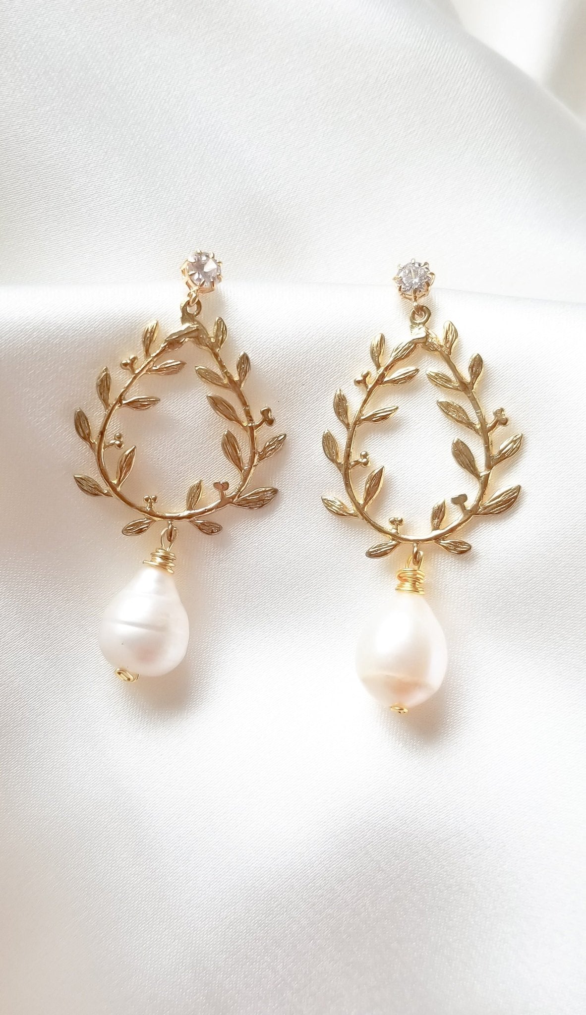 A pair of gold-filled, laurel leaf bridal earrings with freshwater pearl drops and crystal studs on white background. Bridal jewelry Canada. Pearl jewelry Canada. Pearl Bridal jewelry Canada. Gold-filled jewelry Canada. Organic pearl jewelry. Canadian jewelry brands.
