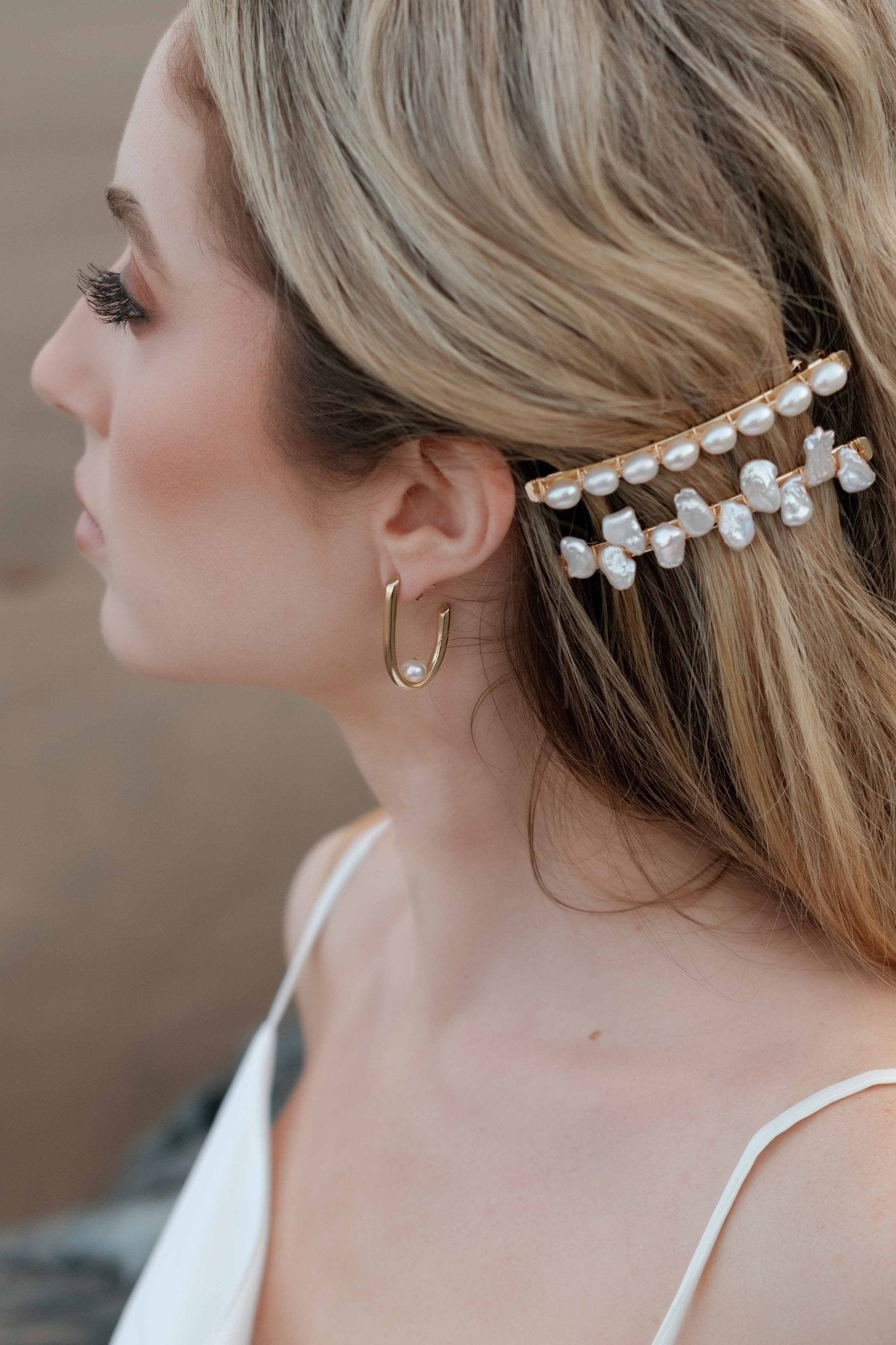 Gold filled hoop earrings with pearl centers on a seaside bride. Gold-filled jewelry Canada. Handmade Canadian jewelry. Woman-owned Canadian jewelry brand. Statement Earrings. Pearl Jewelry. Pearl Bridal Earrings. Bridal Jewelry Canada.