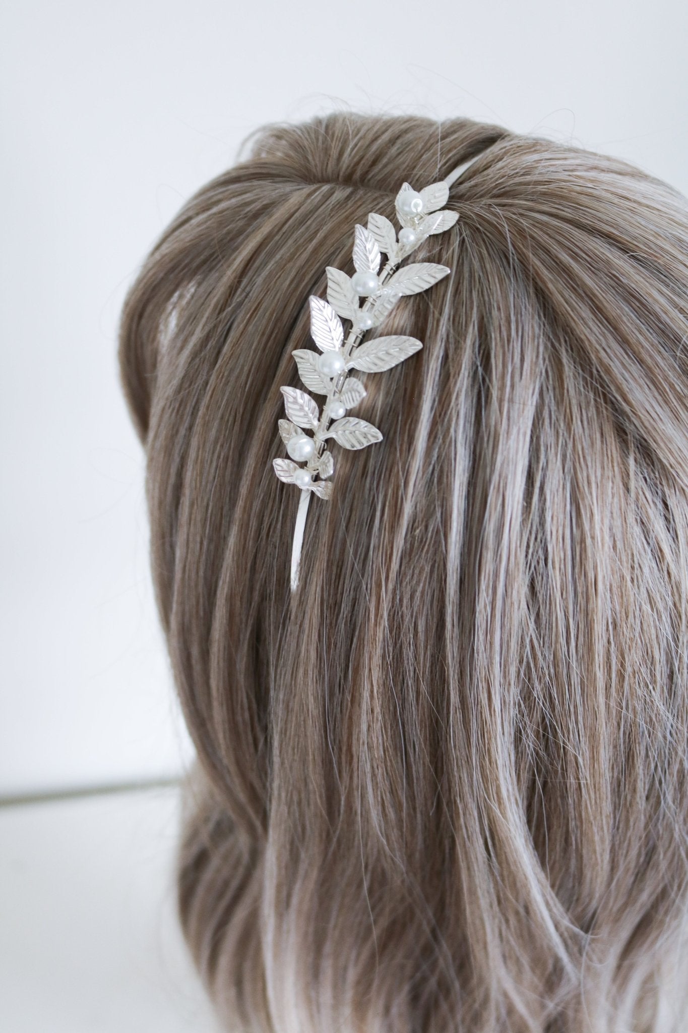 Silver partial laurel leaf headband with pearls against silky hair. Bridal Hair Accessories. Bridal Accessories. Canadian Bridal Accessories. Handmade Canadian Accessories. Canadian handmade Accessories. Canadian weddings. Wedding Canada. Organic pearl accessories. Pearl Bridal Hair Accessories. Pearl Bridal Accessories. Small Canadian jewelry brands.