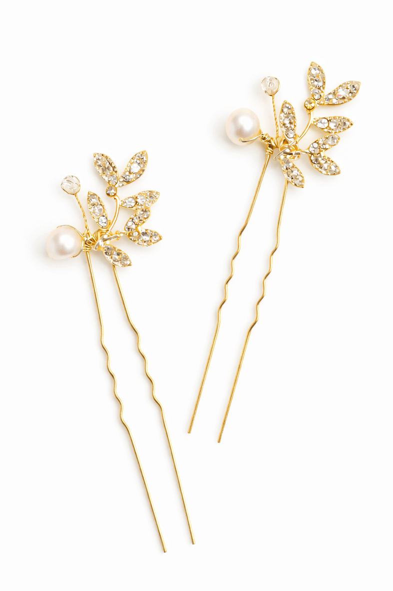 Two gold bridal hairpins with floral designs and freshwater pearls on a white background. Handmade bridal accessories for weddings in Canada by bridal designer