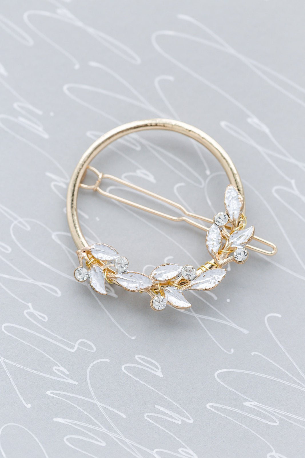 Gold crystal leaf circle bridal hairclip on grey background with white writing. Bridal hair accessories good for everyday wear and weddings handmade by Canadian jewelry brand
