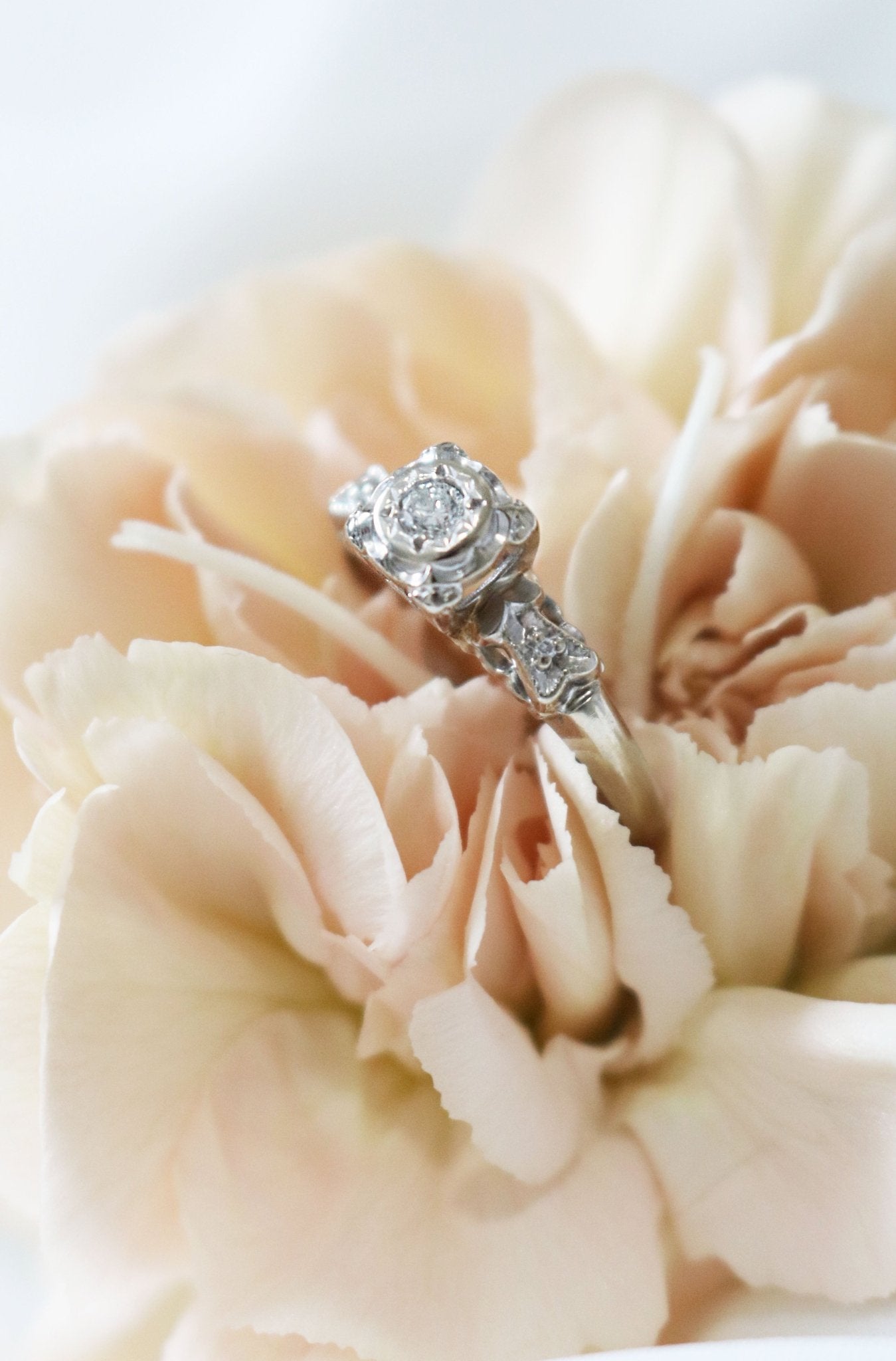 A 14k White Gold Diamond Vintage Engagement Ring nestled in petals of a flower. Canadian vintage engagement rings. Bridal jewelry Canada. Wedding Canada. Small Canadian jewelry brands. Canadian bridal jewelry. Woman-owned Canadian jewelry brand. Canadian jewelry business.