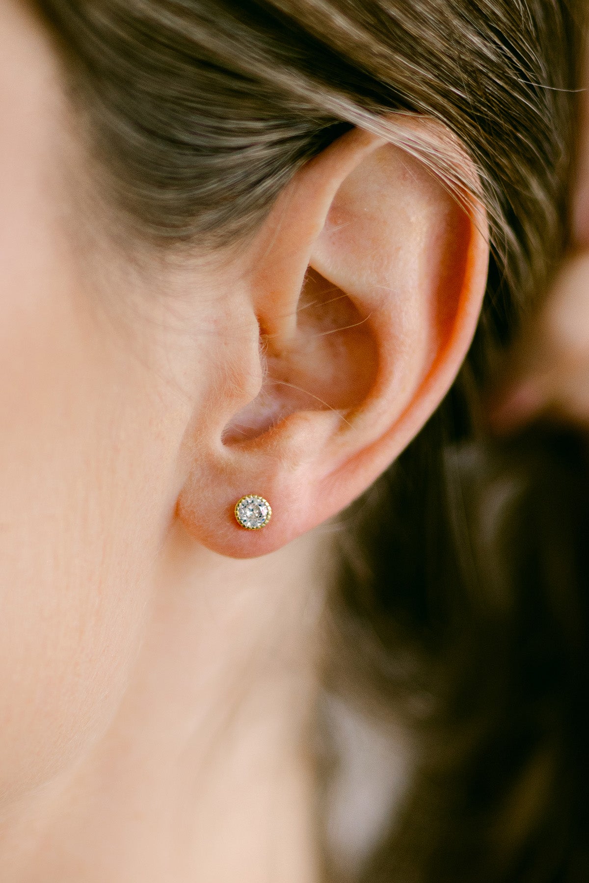 Close-up of an ear wearing a crystal stud earring. Everyday jewelry. Statement Earrings. Small Canadian jewelry brands.