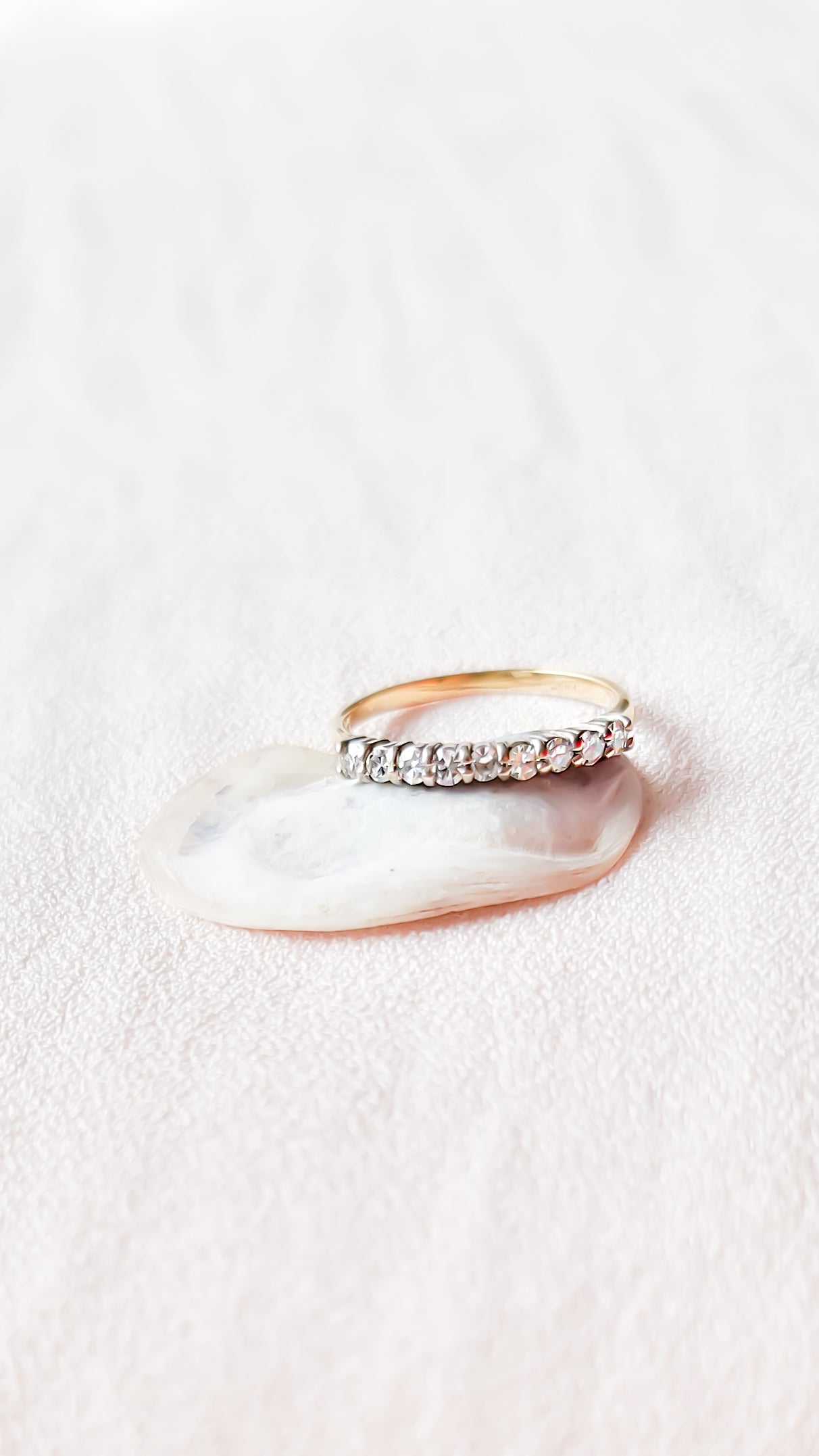The Eva Half Eternity Vintage Diamond Engagement Band in 18k Gold c.1940s sitting on a seashell with a white background. Antique Engagement Rings Canada. Canadian vintage engagement rings. Vintage engagement rings Canada. Bridal jewelry Canada. Canadian weddings. Wedding Canada. Canadian jewelry brands. Affordable Canadian jewelry brands. Canadian bridal jewelry. Woman-owned Canadian jewelry brand. Canadian jewelry business.
