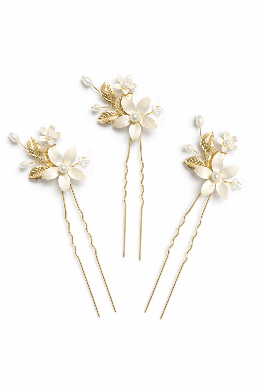 Three gold floral bridal hairpins with hand-enameled white flowers and fresh water pearls on a white background. Handmade bridal accessories & Pearl bridal hair accessories by Canadian bridal designer
