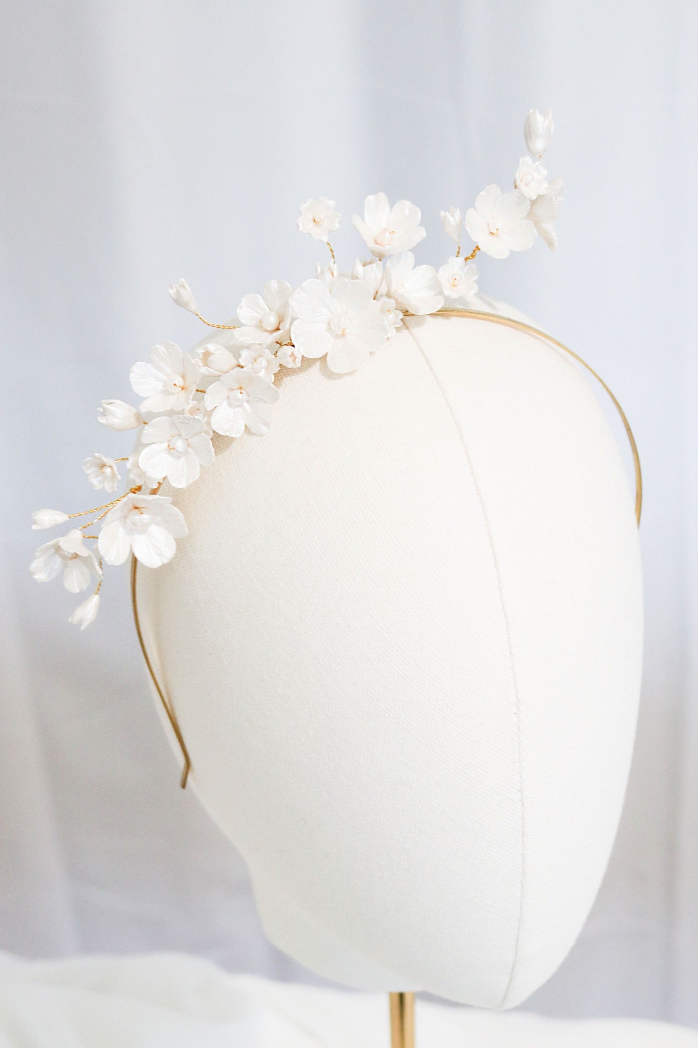 Fleura Fresh Water Pearl and Clay Flower Bridal Headband on a head bust. Bridal Hair Accessories. Bridal Accessories. Canadian weddings. Wedding Canada. Affordable Canadian jewelry brands. Handmade Canadian accessories. Canadian jewelry business. Organic pearl accessories. Canadian jewelry designs. Canadian bridal accessories.