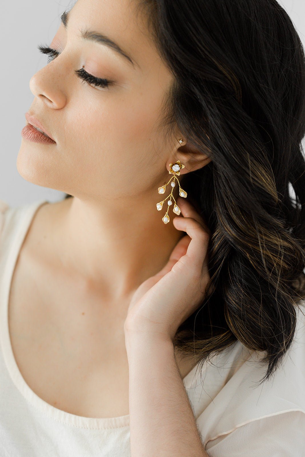 Golden Vine Fresh Water Pearl Leaf Bridal Earrings Set hanging from a woman's ear. Statement Earrings. Statement Bridal Earrings. Bridal jewelry Canada. Pearl jewelry Canada. Pearl Bridal jewelry Canada. Gold-filled jewelry Canada. Gold-filled Canadian jewelry. Handmade Canadian jewelry. Canadian handmade jewelry. Small Canadian jewelry brands. Canadian jewelry brands.