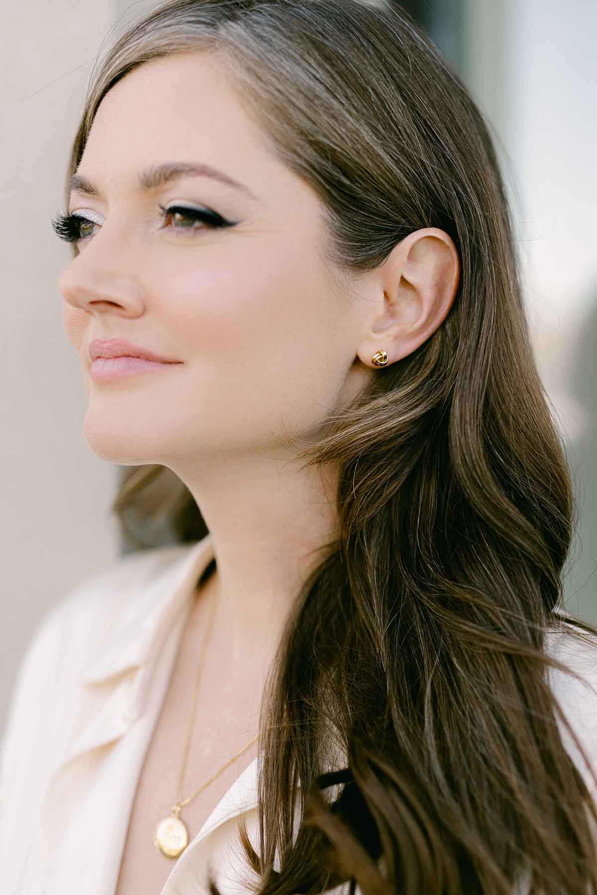 A woman wearing a gold-filled knot stud earring. Woman-owned Canadian jewelry brand. Gold-filled Canadian jewelry. Affordable jewelry.