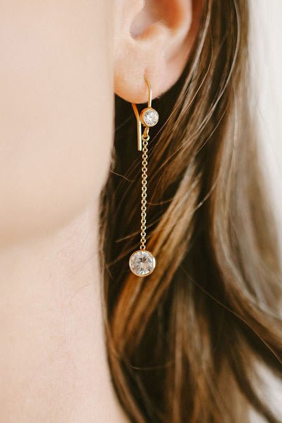 Close up of gold-filled crystal dangle earring on ear. Canadian handmade jewelry. Minimal bridal jewelry.