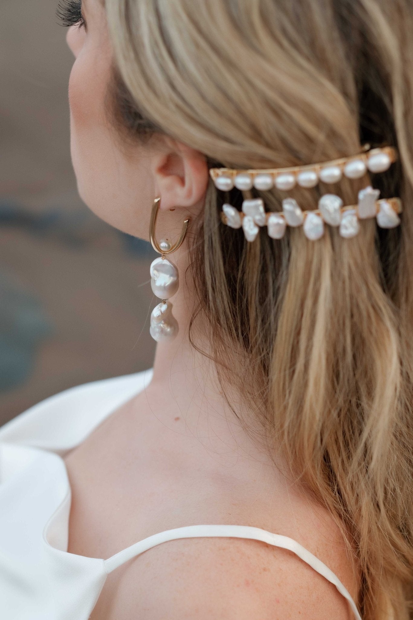 Side view of a bride wearing gold-filled freshwater pearl bridal earrings with baroque pearls. Pearl jewelry Canada. Pearl Bridal jewelry Canada.