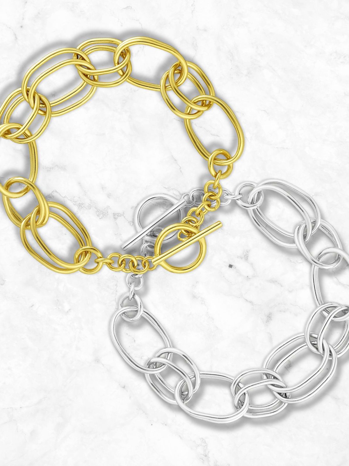 Two chain-link bracelets; one gold and one sterling silver, on a light background.