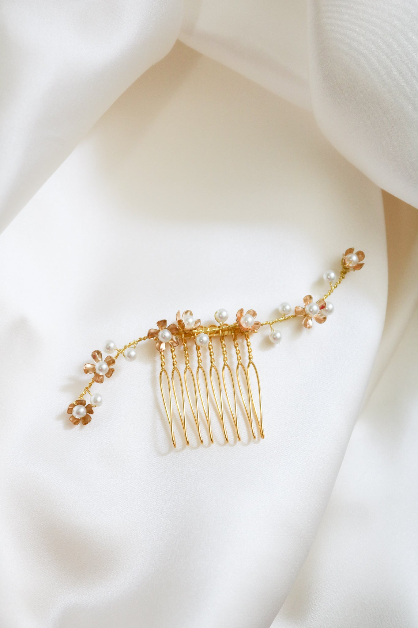 A close up of a shorter gold freshwater pearl floral bridal hair comb displayed on the side of a mannequin head. Bridal Hair Accessories. Bridal Accessories. Canadian Bridal Accessories. Handmade Canadian Accessories. Canadian handmade Accessories. Canadian weddings. Wedding Canada. Organic pearl accessories. Pearl Bridal Hair Accessories. Pearl Bridal Accessories.