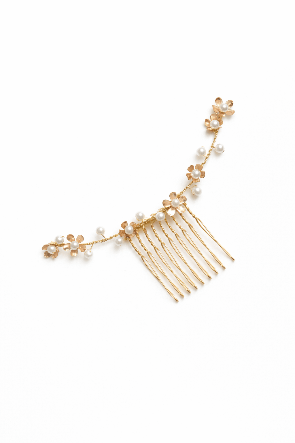 Gold bridal hair comb with floral embellishments and pearls on a white background. Handmade bridal accessories & pearl bridal hair accessories by Canadian BIPOC wedding designer