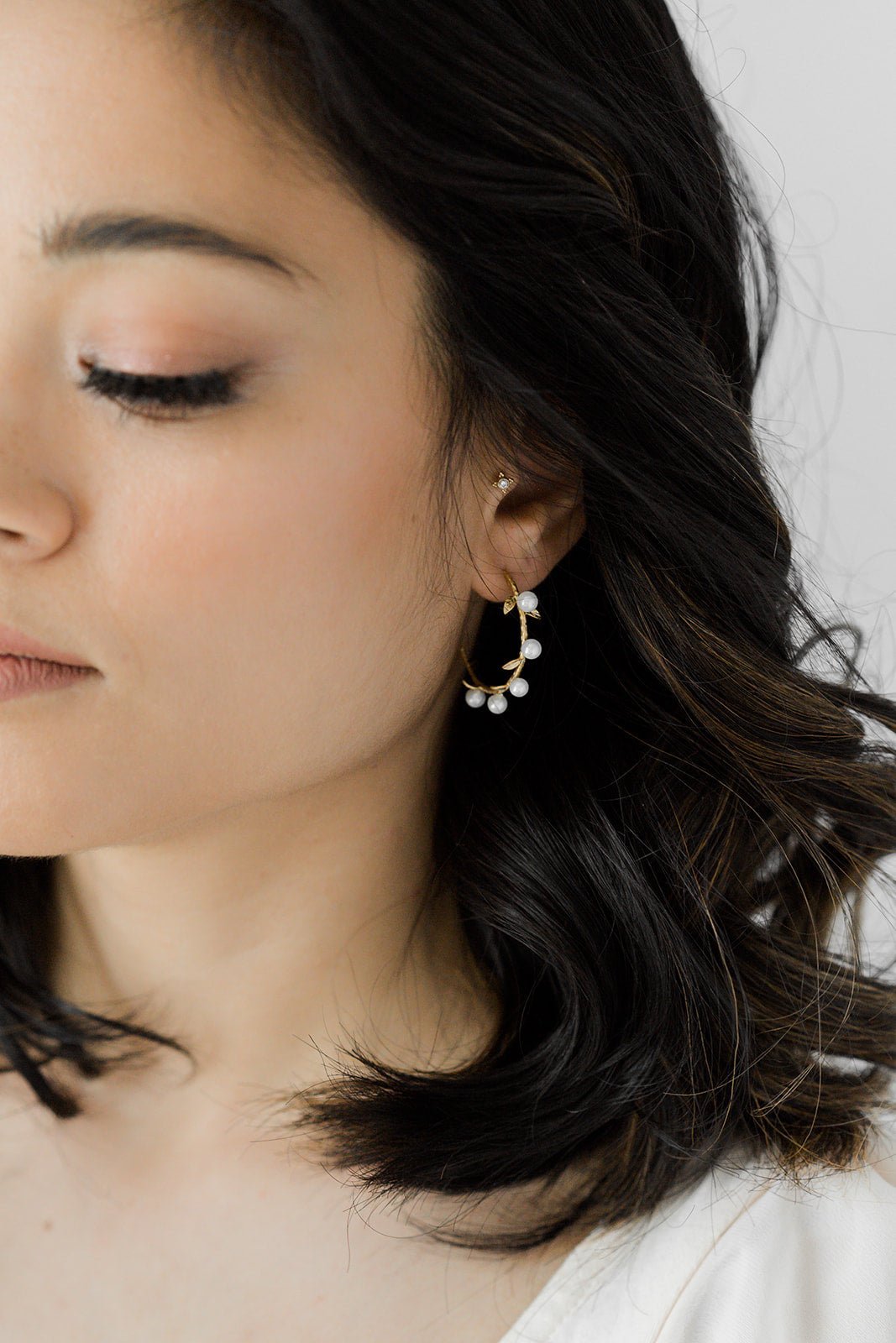 A gold-filled hoop with laurel leaf branches and freshwater pearls on a woman's ear. Pearl jewelry Canada, Pearl Bridal Jewelry Canada, Gold-filled Jewelry Canada.