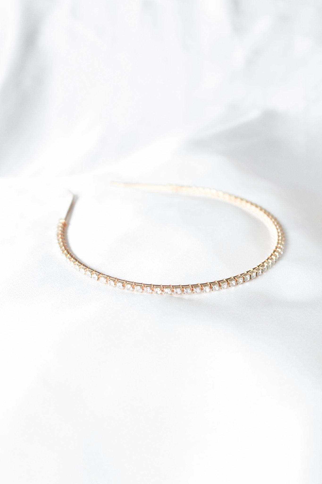 A Gold Crystal Halo Bridal headband on a white satin sheet. Bridal Hair Accessories. Bridal Accessories. Canadian Bridal Accessories. Handmade Canadian Accessories. Canadian handmade Accessories. Canadian weddings. Wedding Canada. Canadian designer. Canadian artist.