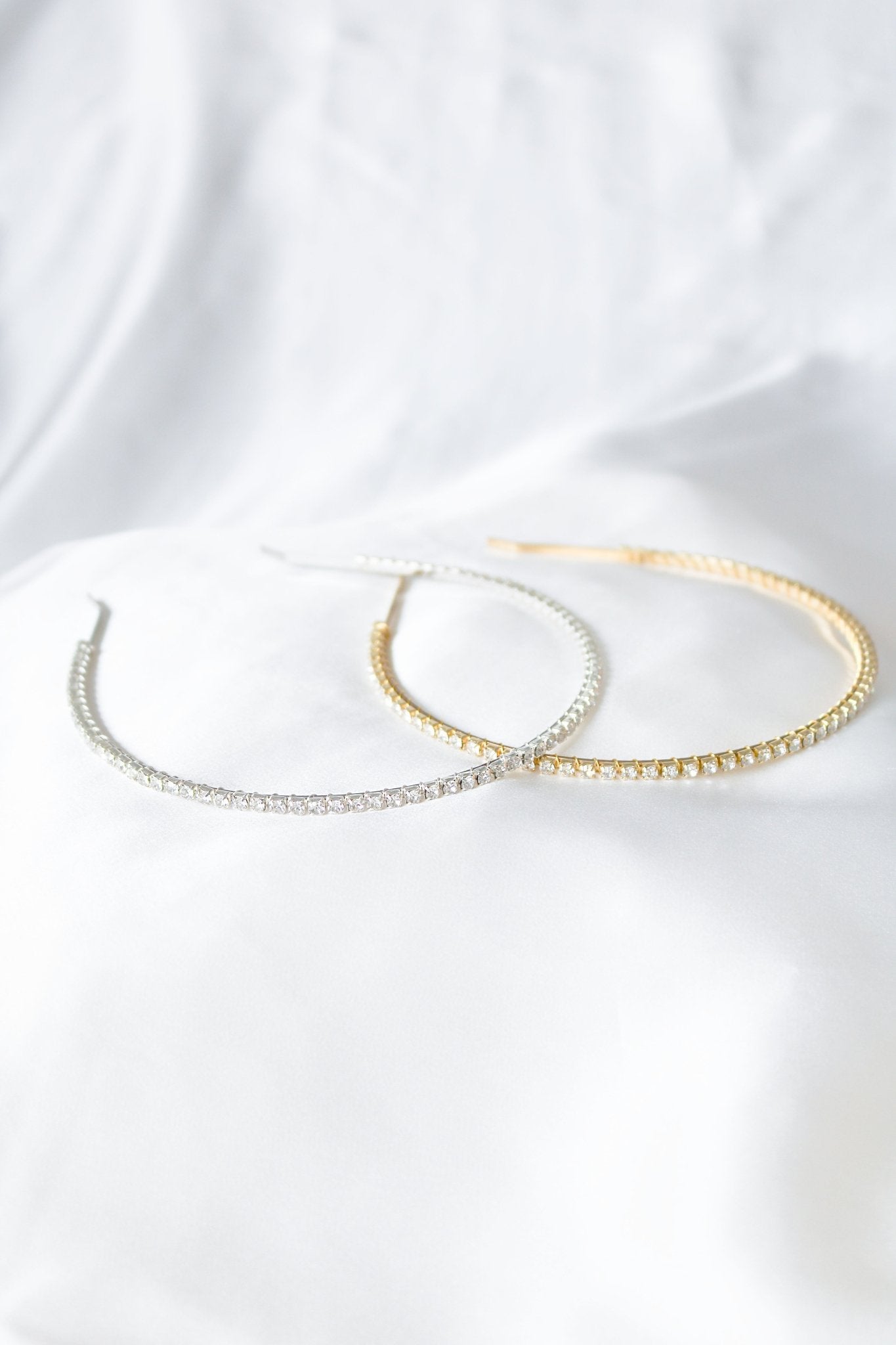 A Gold and Silver Crystal Halo headbands on a white satin sheet. Bridal Hair Accessories. Bridal Accessories. Canadian Bridal Accessories. Handmade Canadian Accessories. Canadian handmade Accessories. Canadian weddings. Wedding Canada. Canadian designer. Canadian artist.