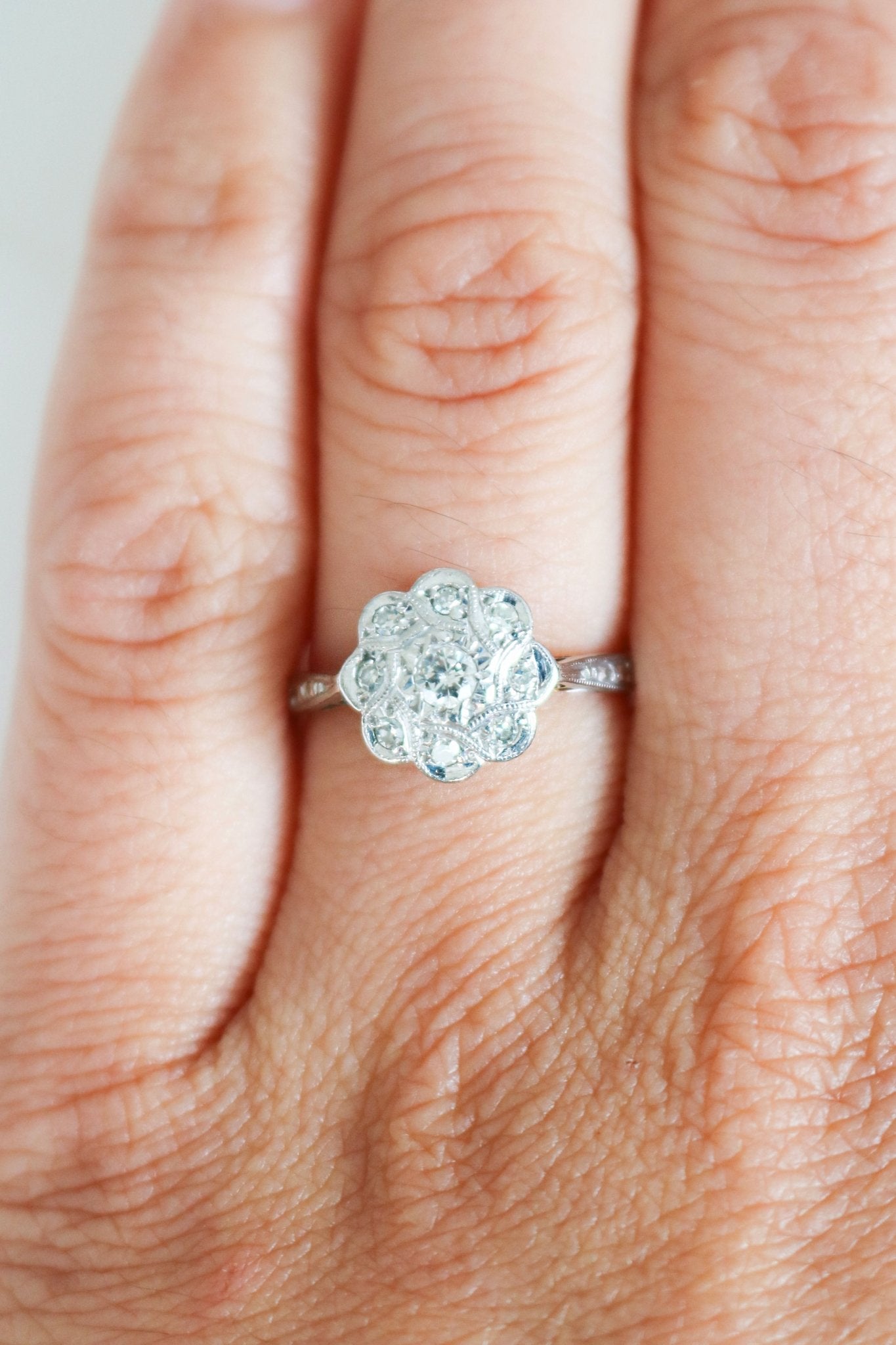 Vintage Engagement Ring in 18k Yellow Gold and Platinum with Diamonds in Flower shape on ring finger. Canadian vintage engagement rings. Bridal jewelry Canada. Vintage engagement rings Canada. Canadian weddings. Wedding Canada. Woman-owned Canadian jewelry brand. Canadian jewelry business. Small Canadian jewelry brands.