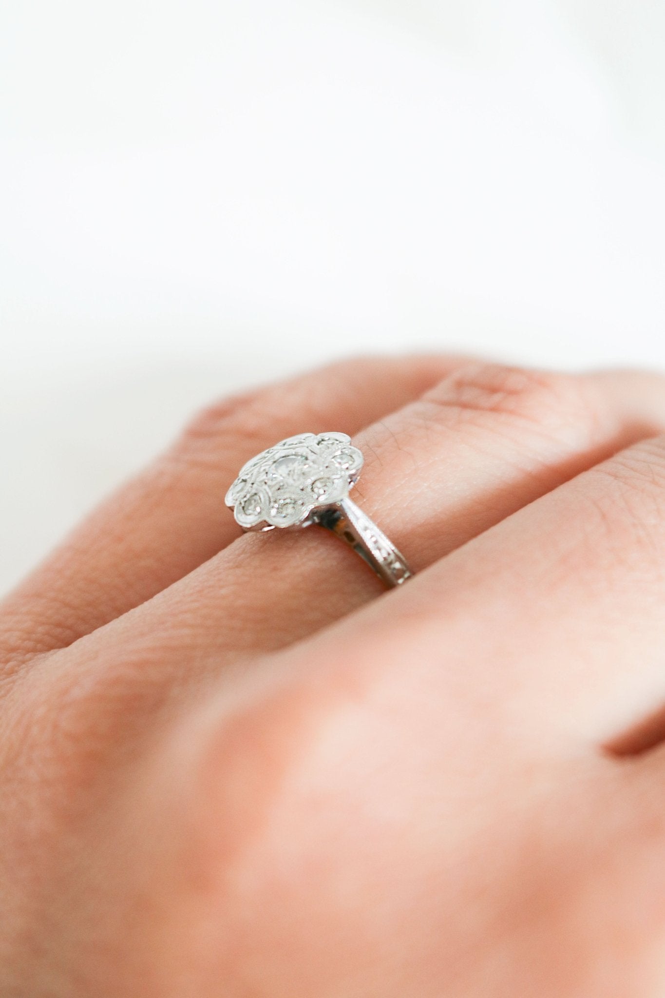 Side view of a Vintage Engagement Ring in 18k Yellow Gold and Platinum with Diamonds in Flower shape on ring finger. Canadian vintage engagement rings. Bridal jewelry Canada. Vintage engagement rings Canada. Canadian weddings. Wedding Canada. Woman-owned Canadian jewelry brand. Canadian jewelry business. Small Canadian jewelry brands.