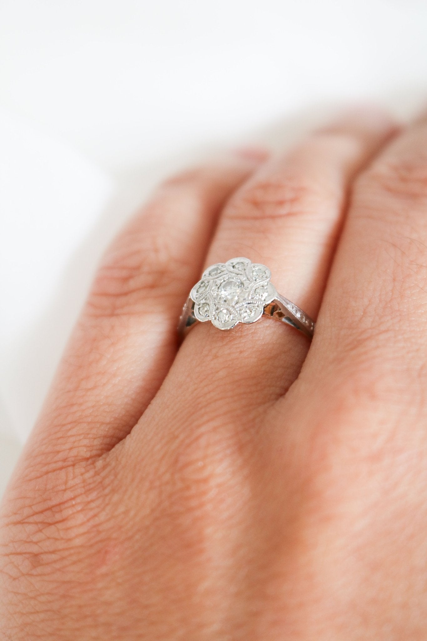 Side view of a Vintage Engagement Ring in 18k Yellow Gold and Platinum with Diamonds in Flower shape on ring finger. Canadian vintage engagement rings. Bridal jewelry Canada. Vintage engagement rings Canada. Canadian weddings. Wedding Canada. Woman-owned Canadian jewelry brand. Canadian jewelry business. Small Canadian jewelry brands.