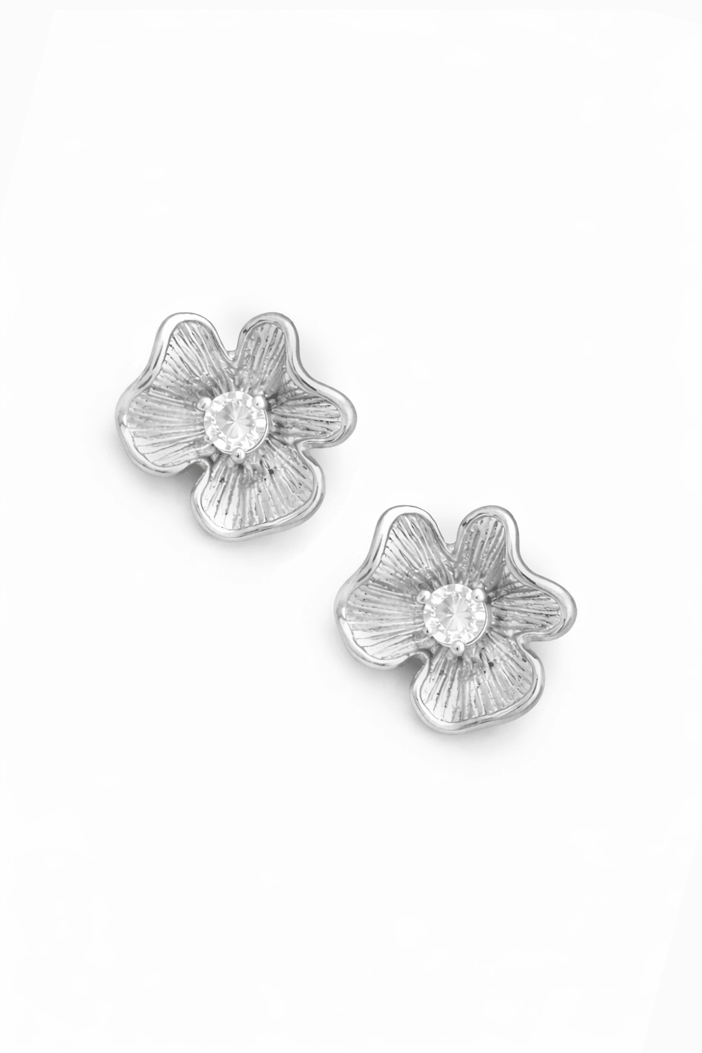 Sterling silver flower-shaped earrings with crystal centers on a white background. Handmade Canadian jewellery by BIPOC jewelry designer