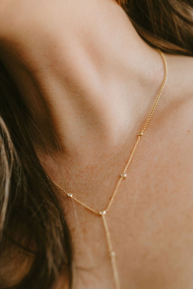 Close up of a neck with gold-filled lariat style necklace with crystal links. Affordable Canadian jewelry brands. Handmade Canadian jewelry.
