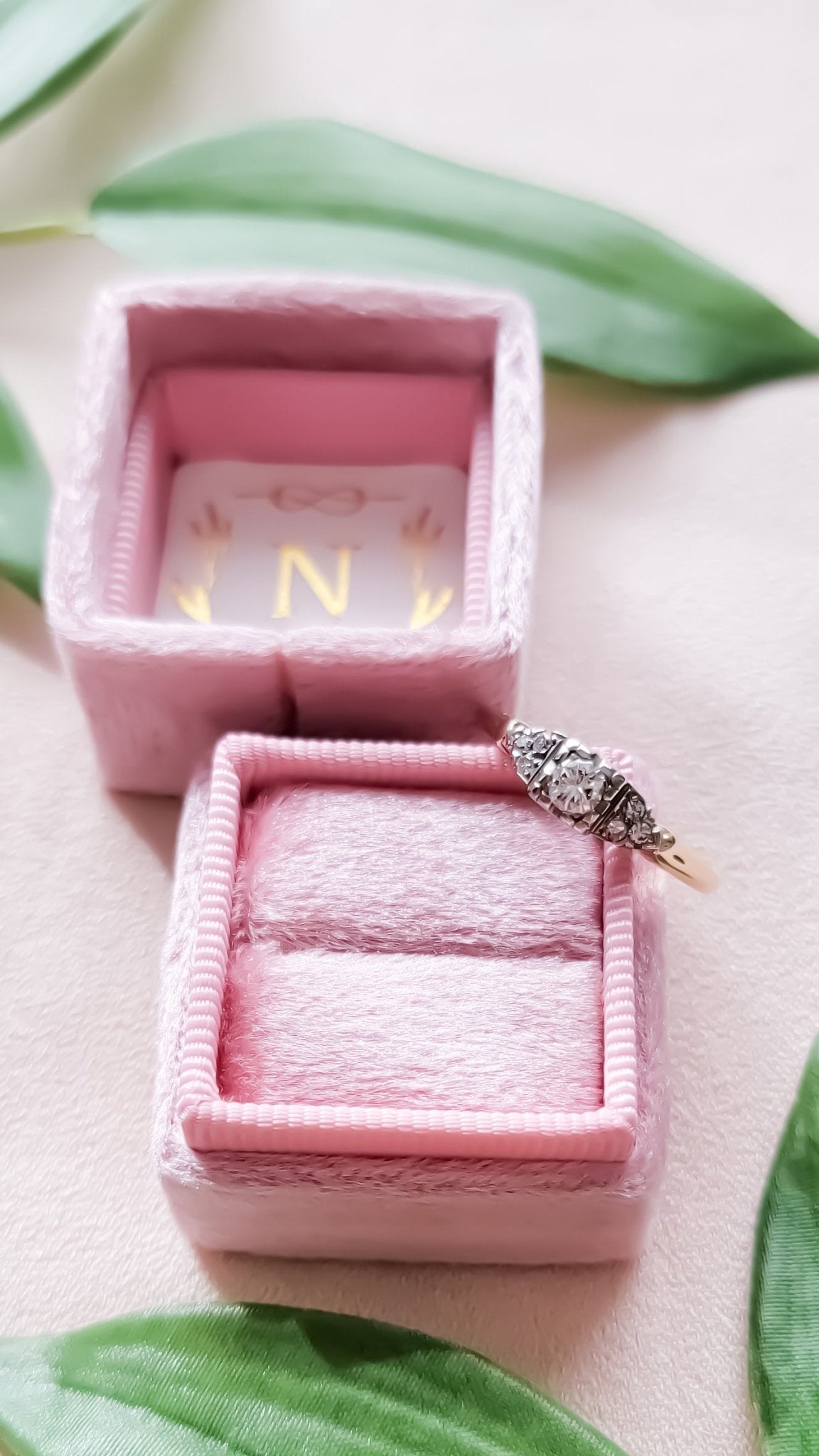 Top view of the Lisbet Vintage Diamond Engagement Ring in 14k Gold, 1930s Art Deco style leaning against a box surrounded by leaves. Antique Engagement Rings Canada. Canadian vintage engagement rings. Vintage engagement rings Canada. Bridal jewelry Canada. Canadian bridal jewelry. Woman-owned Canadian jewelry brand. Canadian jewelry business. Canadian weddings.