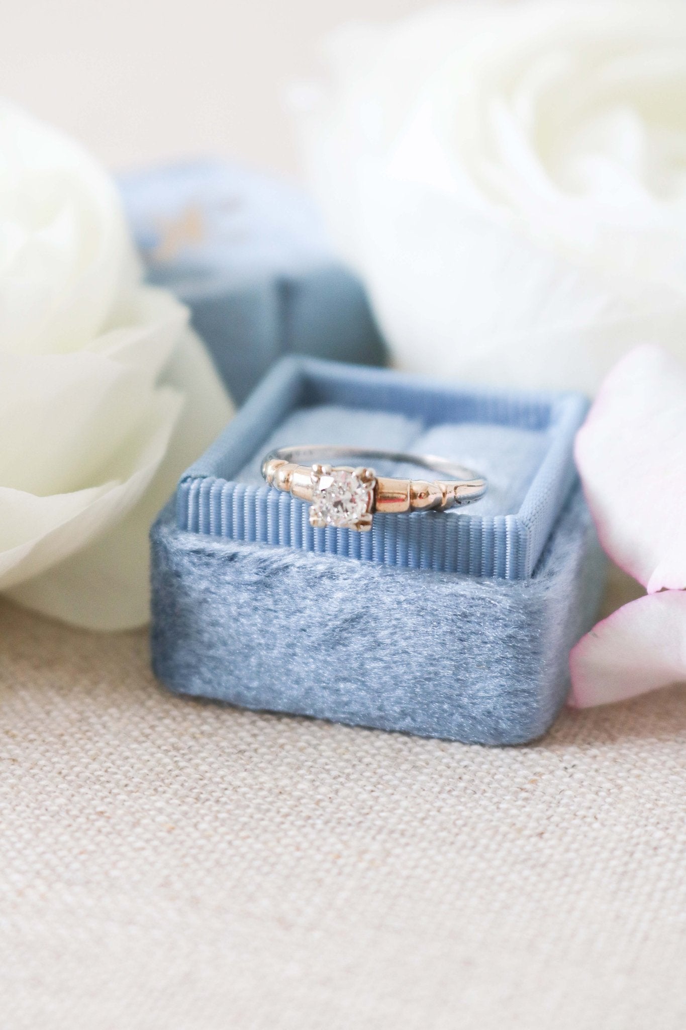 A 14ct Gold Diamond Engagement Ring on top of a ring box surrounded by white roses. Antique Engagement Rings Canada. Canadian vintage engagement rings. Vintage engagement rings Canada. Bridal jewelry Canada. Canadian weddings. Wedding Canada. Canadian bridal jewelry. Woman-owned Canadian jewelry brand. Canadian jewelry business.