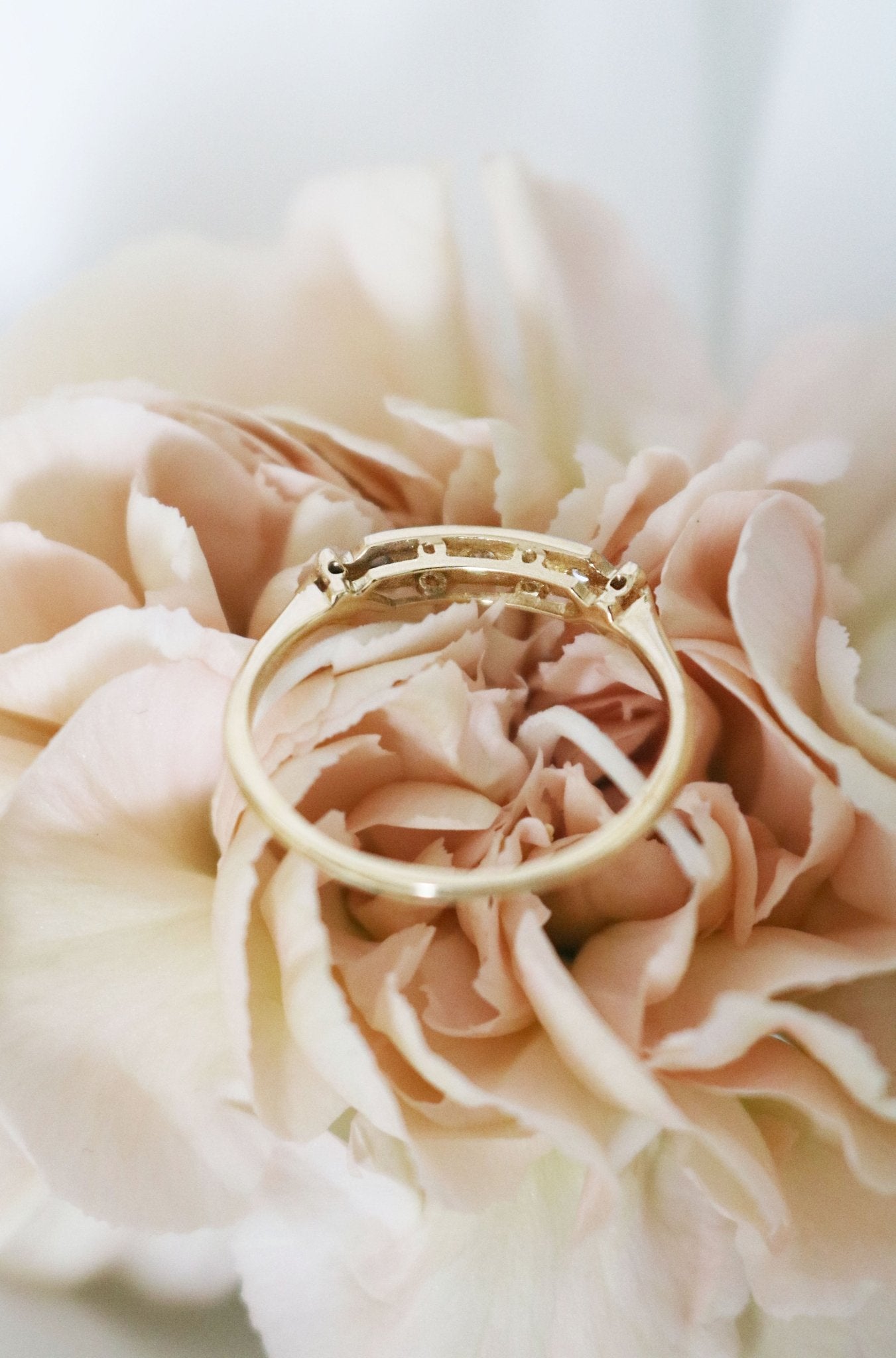 The back view of A Diamond Vintage Engagement Ring/Wedding Band in 18k Yellow and White Gold laying atop a golden flower. Canadian vintage engagement rings. Bridal jewelry Canada. Canadian weddings. Wedding Canada. Small Canadian jewelry brands. Canadian jewelry brands. Affordable Canadian jewelry brands.
