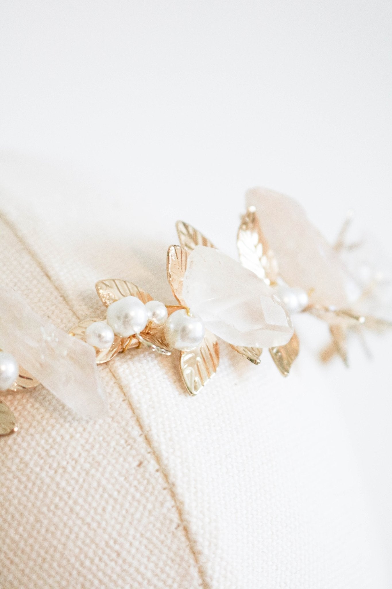 Extreme close up of a gold laurel bridal headband with pearls and quartz crystals on a head bust. Handmade bridal accessories & bridal hairpieces by BIPOC jewelry designer