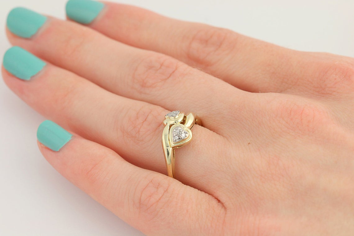 A close up side view of the Love Bird double diamond heart 10k gold engagement ring on a ring finger. Antique Engagement Rings Canada. Canadian vintage engagement rings. Vintage engagement rings Canada. Bridal jewelry Canada. Canadian weddings. Wedding Canada. Canadian jewelry brands. Affordable Canadian jewelry brands. Canadian bridal jewelry. Woman-owned Canadian jewelry brand.