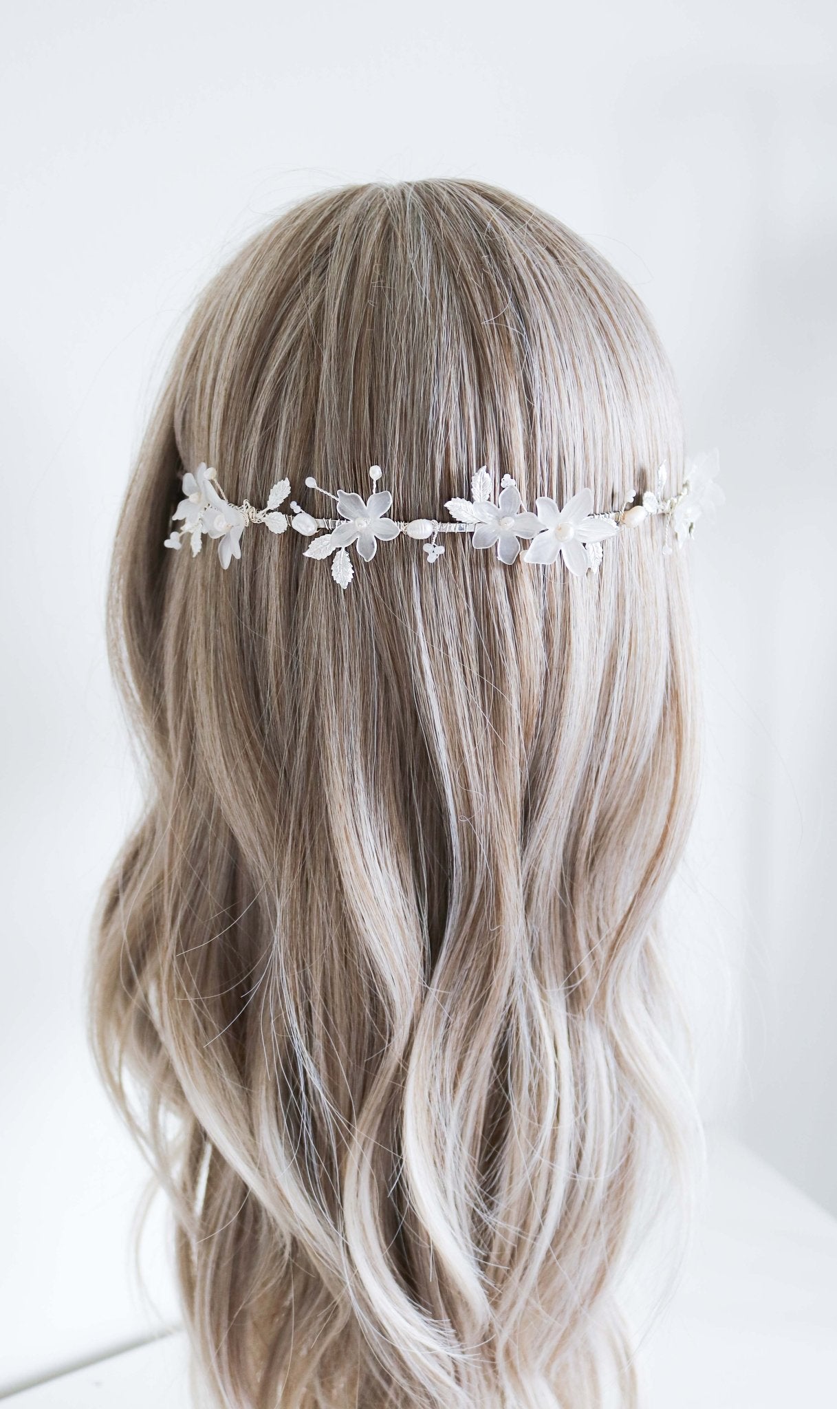 The Melody Fresh Water Pearl and Floral Bridal Headband running across the back of a head bust wig. Bridal Hair Accessories. Bridal Accessories. Canadian Bridal Accessories. Handmade Canadian Accessories. Canadian handmade Accessories. Organic pearl accessories. Canadian weddings. Wedding Canada.