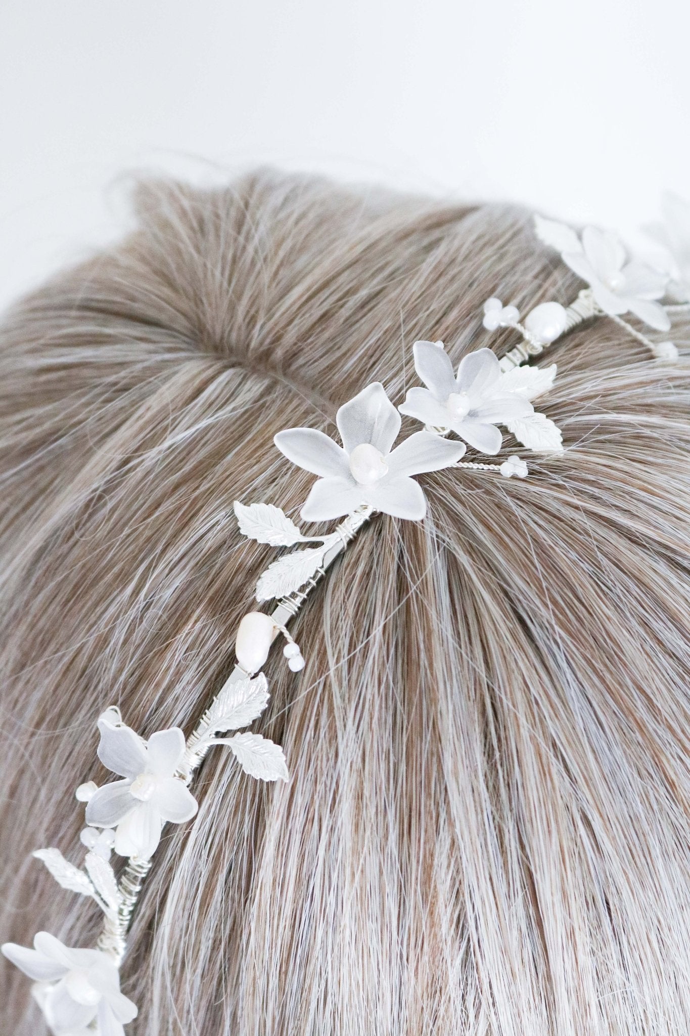 An extreme close up of the Melody Fresh Water Pearl and Floral Bridal Headband on a head bust wig. Bridal Hair Accessories. Bridal Accessories. Canadian Bridal Accessories. Handmade Canadian Accessories. Canadian handmade Accessories. Organic pearl accessories. Canadian weddings. Wedding Canada.