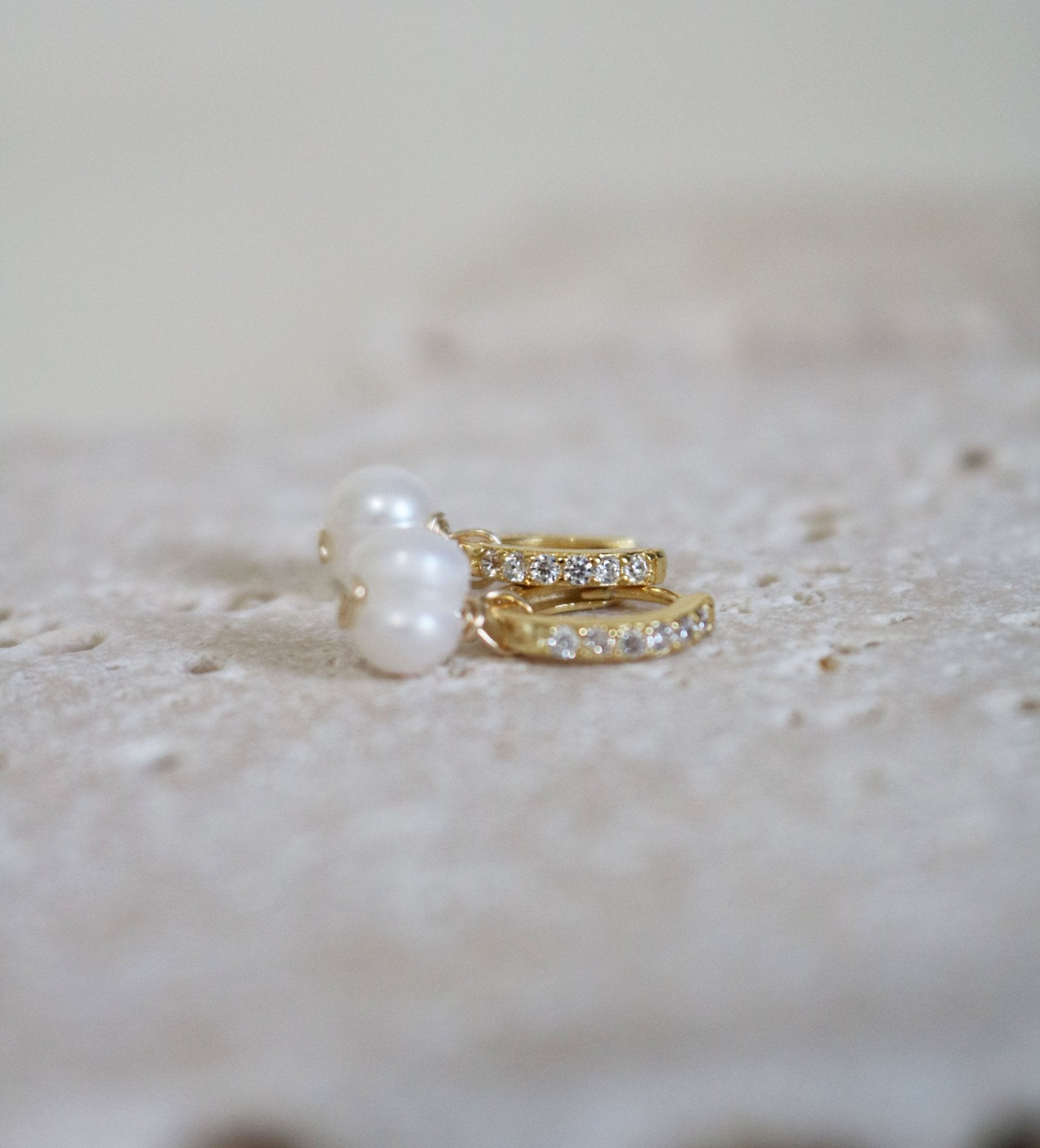 A pair of cubic zirconia encrusted gold-filled pearl huggies. Canadian jewelry designs. Bridal jewelry Canada. Pearl jewelry Canada. Pearl Bridal jewelry Canada. Gold-filled jewelry Canada. Organic pearl jewelry. Canadian bridal jewelry.