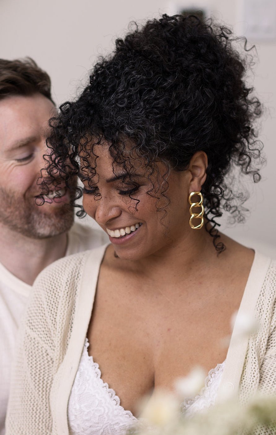 Woman laughs with her partner while wearing her Puffy Gold Filled Chain Link Earrings. Gold-filled jewelry Canada. Handmade Canadian jewelry. Canadian jewelry designer. Handmade jewelry Canada. Canadian handmade jewelry. Small Canadian jewelry brands. Canadian jewelry business. Statement Earrings.