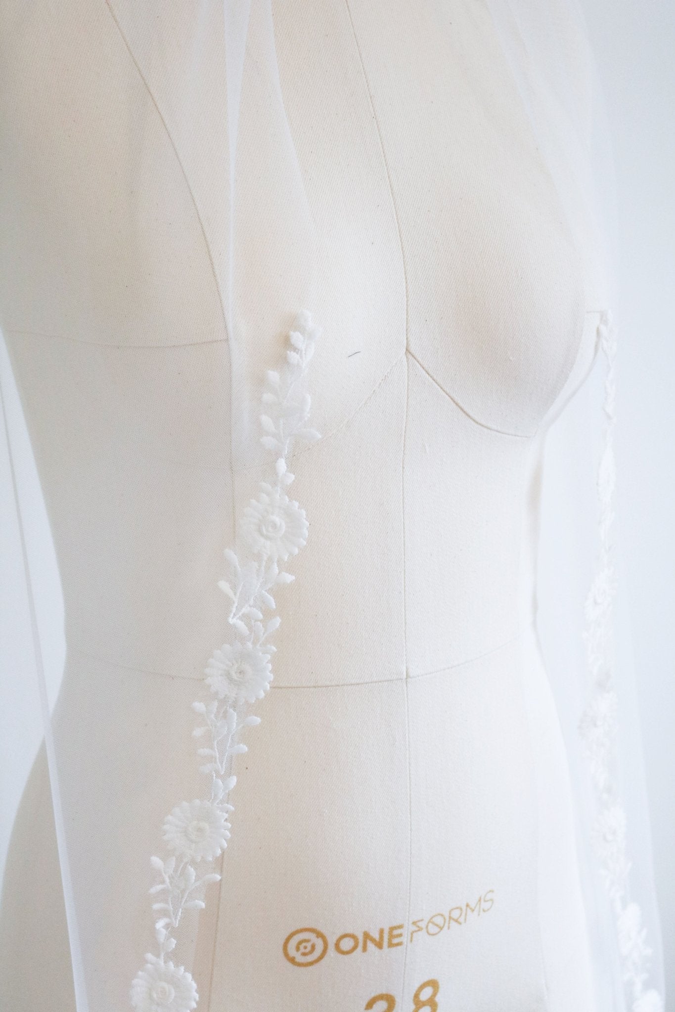 The Sienna Floral Vine Bridal Veil framing a white mannequin. Canadian weddings. Wedding Canada. Wedding veils Canada. Bridal Hair Accessories. Bridal Accessories. Canadian Bridal Accessories. Handmade Canadian Accessories. Canadian handmade Accessories. Canadian designer. Canadian artist.