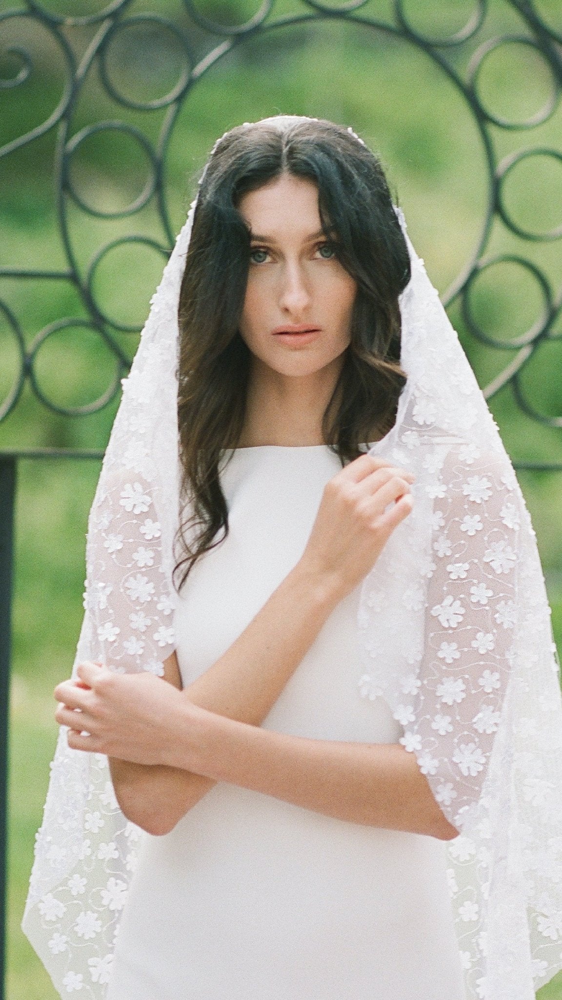 A bride wrapped in lace and tulle holds her Sonnet floral wedding veil close. Canadian weddings. Wedding Canada. Wedding veils Canada. Bridal Hair Accessories. Bridal Accessories. Canadian Bridal Accessories. Handmade Canadian Accessories. Canadian handmade Accessories. Canadian designer. Canadian artist.