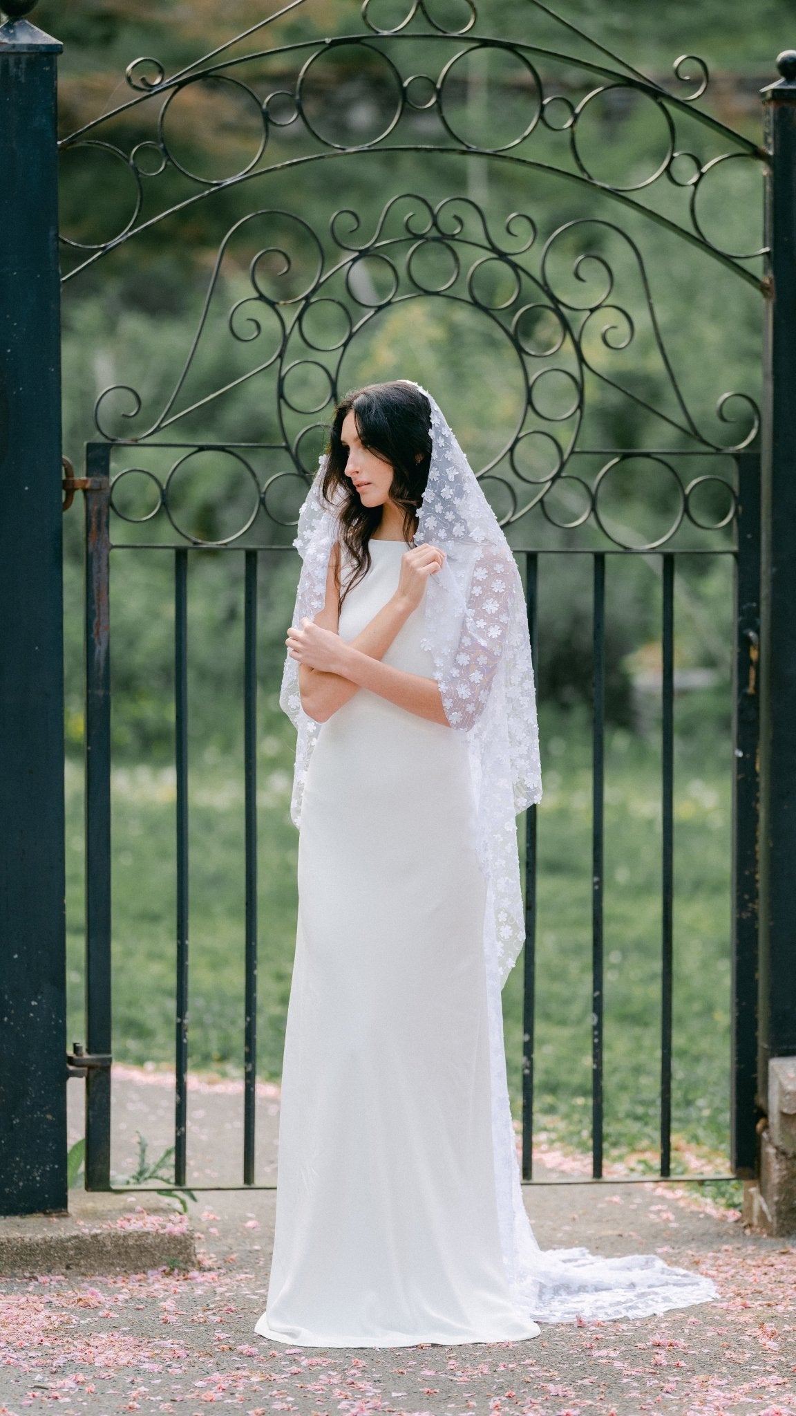 Full shot of a bride looking conservative as she pulls her Sonnet floral wedding veil close. Canadian weddings. Wedding Canada. Wedding veils Canada. Bridal Hair Accessories. Bridal Accessories. Canadian Bridal Accessories. Handmade Canadian Accessories. Canadian handmade Accessories. Canadian designer. Canadian artist.