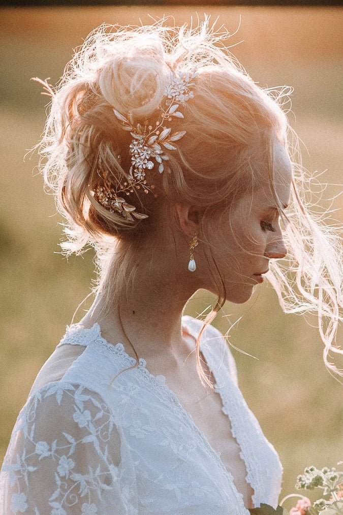 Bride at sunset with intricate gold bridal hairpiece with enamel flowers and Swarovski crystals wearing a white lace wedding dress in a natural setting. Bridal hairvine, bridal hair accessories, & handmade bridal accessories Canada