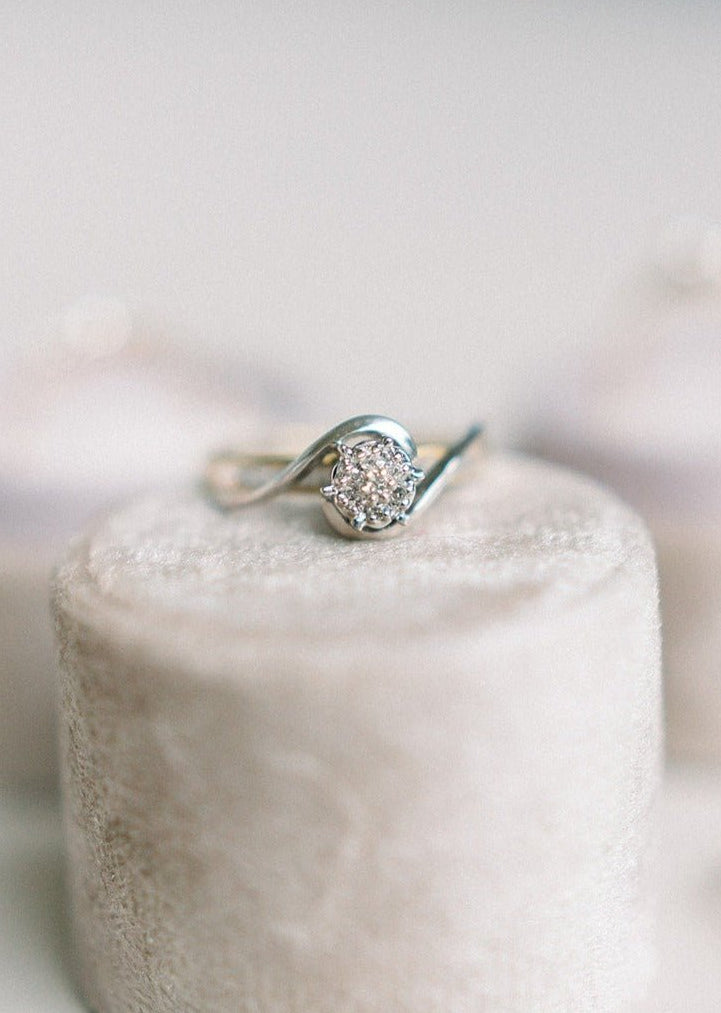 White and yellow gold vintage engagement ring with large diamond sitting on a beige ring box with neutral background. Antique wedding rings, antique engagement rings, & vintage rings Canada