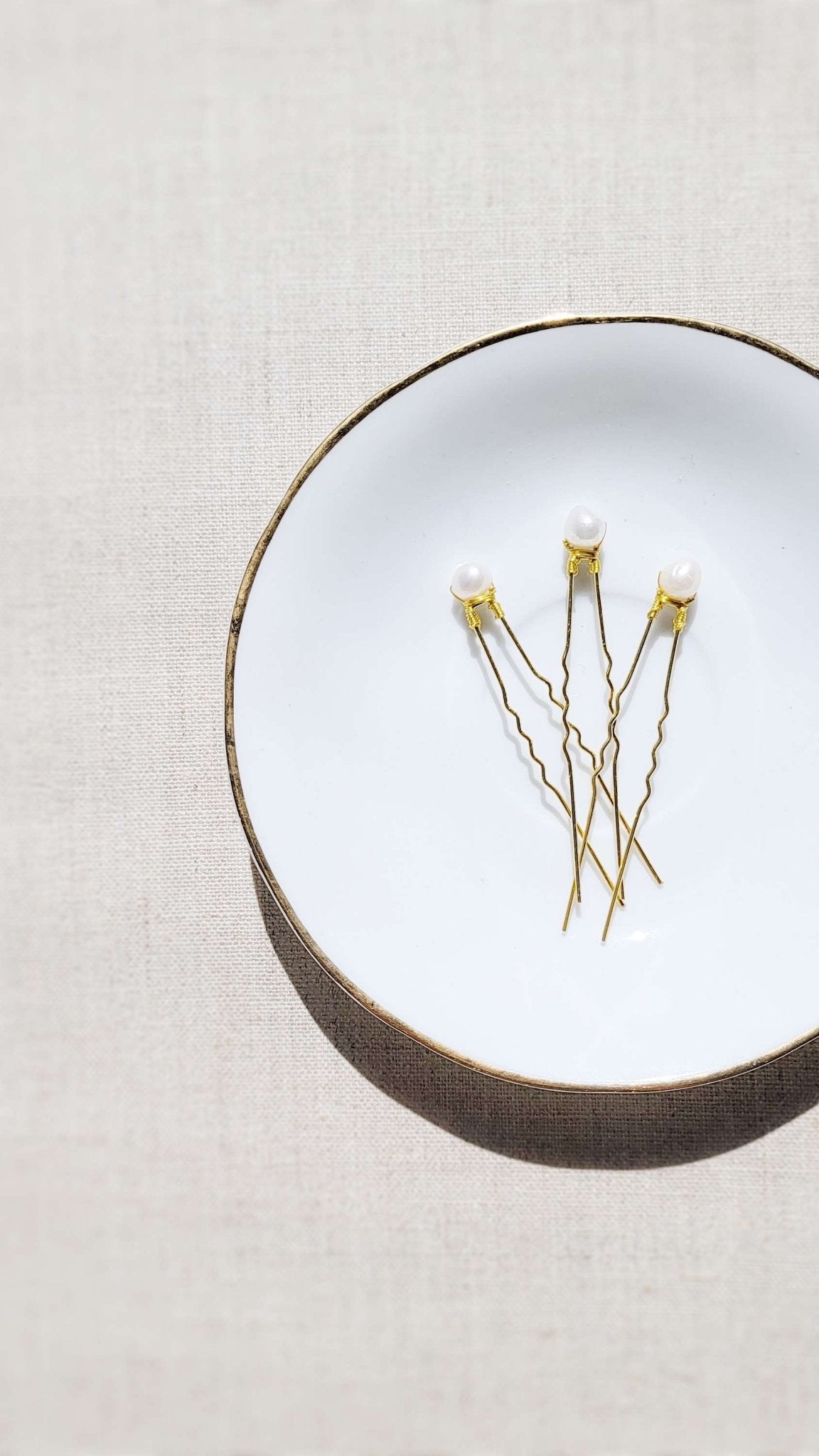 Three Gold Tess Fresh Water Pearl Hairpins on a white dish. Organic pearl jewelry. Bridal jewelry Canada. Pearl jewelry Canada. Pearl Bridal jewelry Canada.  Canadian jewelry maker. Canadian bridal jewelry. Bridal hair accessories. Bridal accessories.