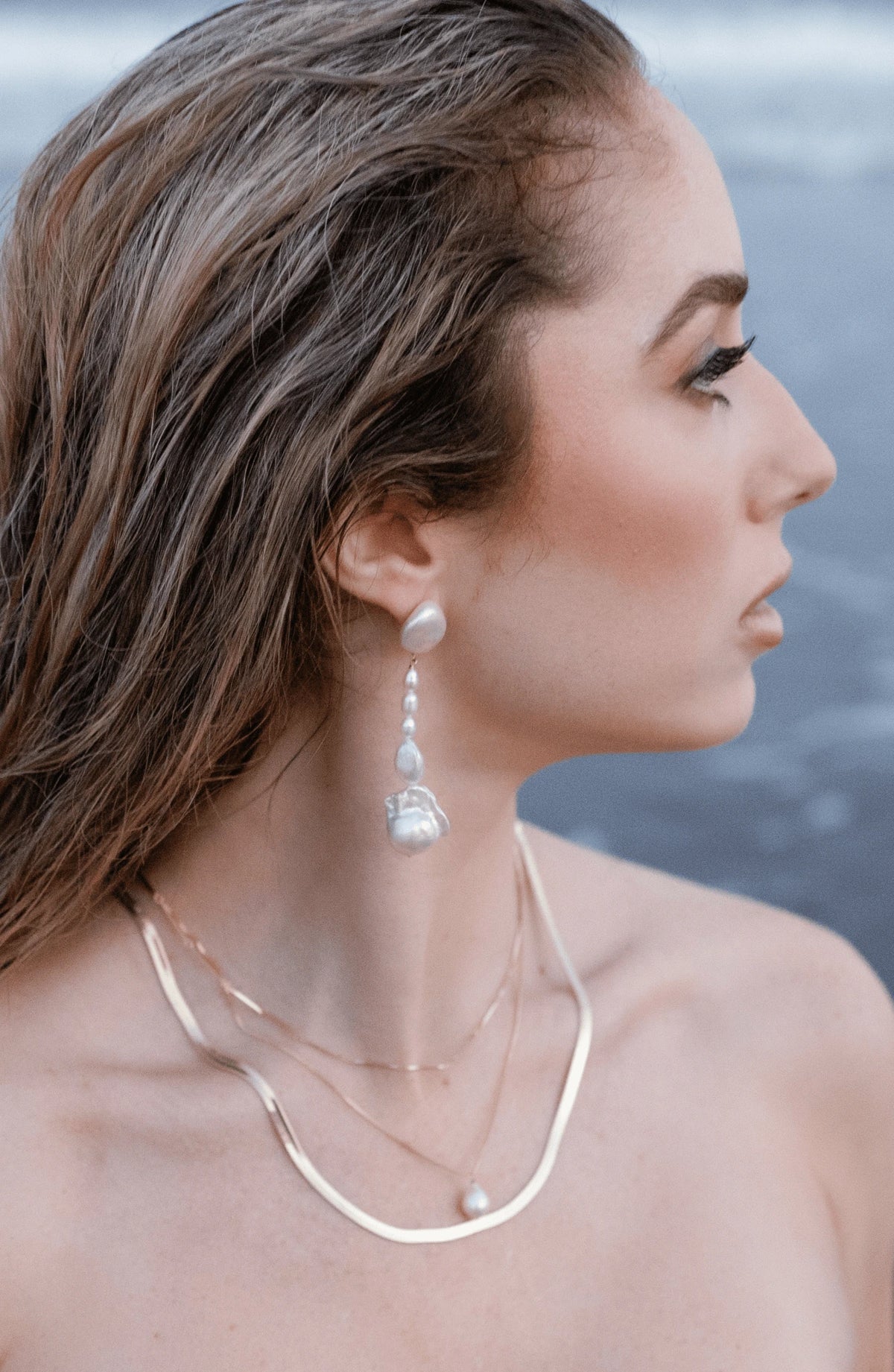 A seaside goddess with stacked gold-filled necklaces and freshwater pearl dangle earrings. Canadian jewelry with freshwater pearls. Handmade jewellery by Canadian jewellery designer