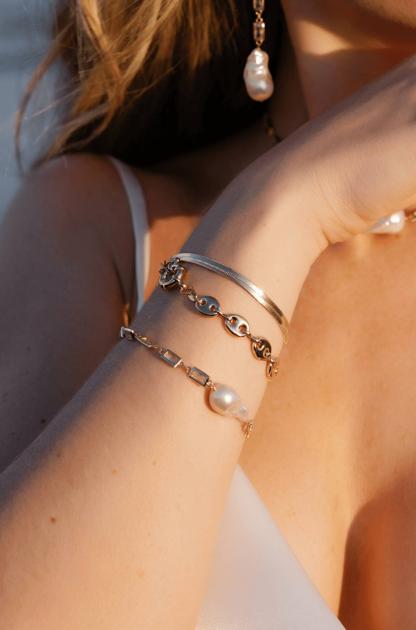 A bracelet stack consisting of the puffy mariner link bracelet, herringbone, and gold-filled crystal link baroque pearl bracelet. Gold-filled jewelry Canada. Canadian jewelry designs.